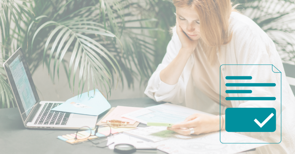 Female Landlord with red hair at desk looking through tenant rental documents