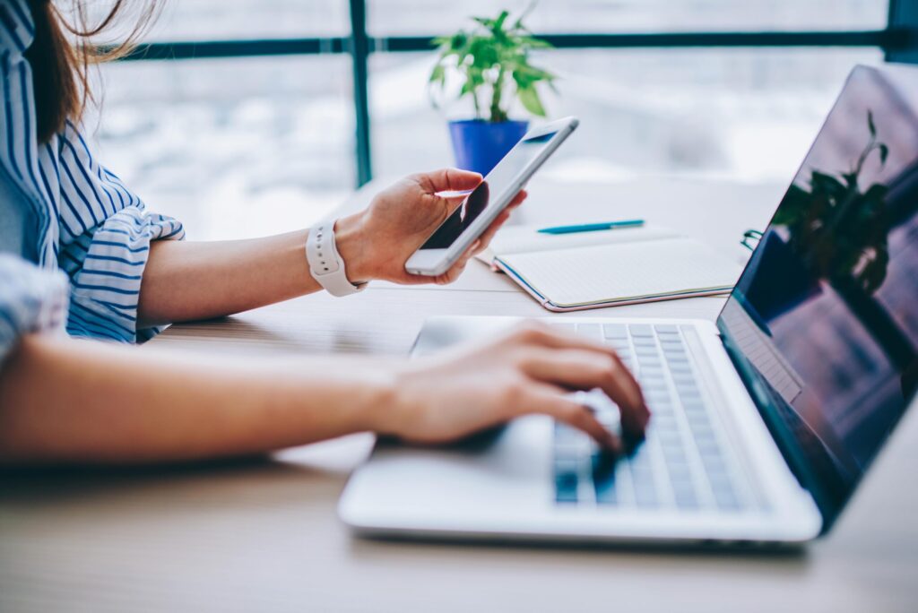 female landlord on phone and laptop screening tenant applications