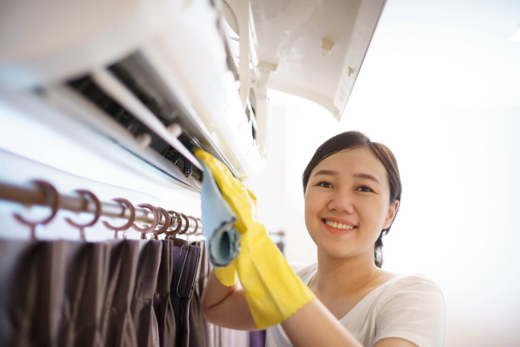 Female tenant performing tenant maintenance responsibilites by cleaning air conditioner