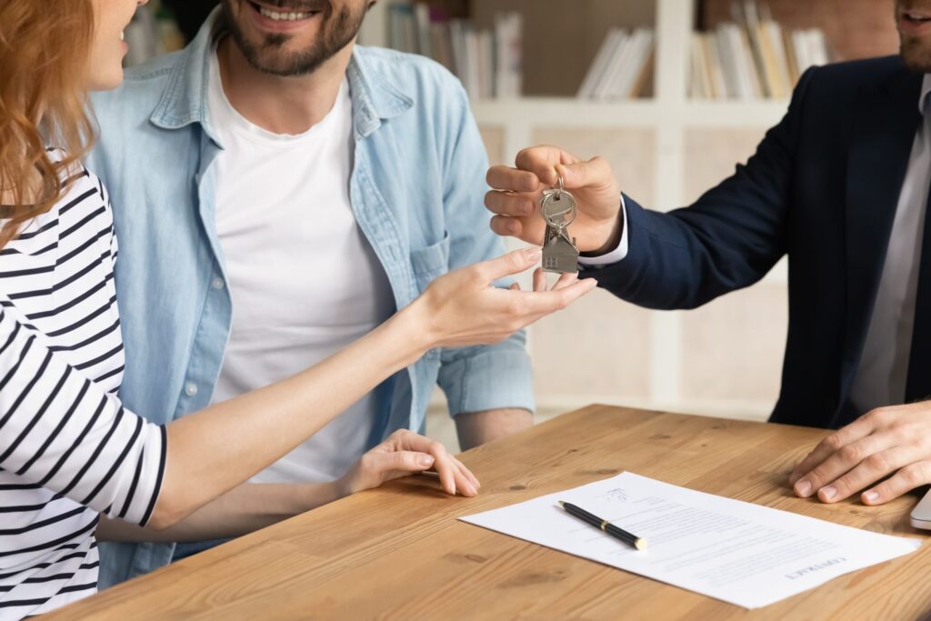 Man and woman being handed keys to home after completing rent to own contract.