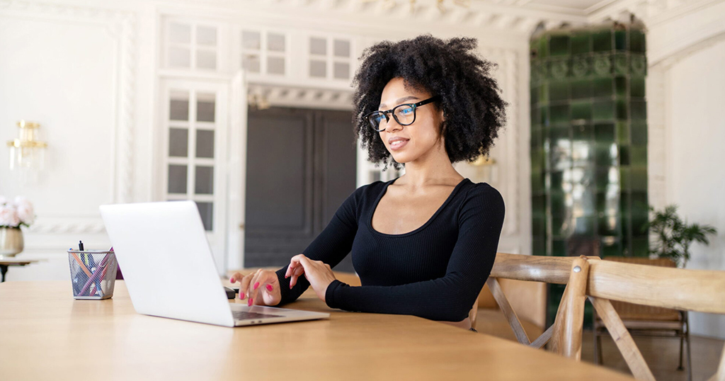 Female Landlord in office on laptop reporting Tenant rent payments.