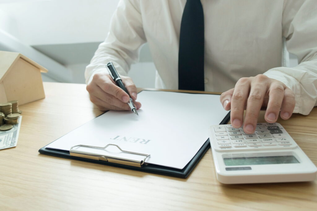 Landlord documenting unpaid rent on paper.
