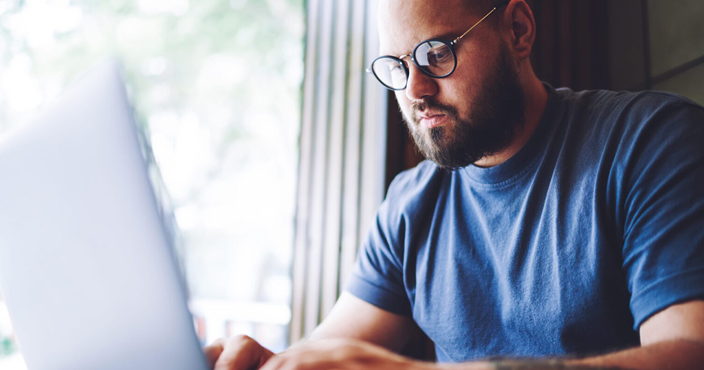 Male Landlord with beard reporting Tenant rent payments on laptop to FrontLobby.