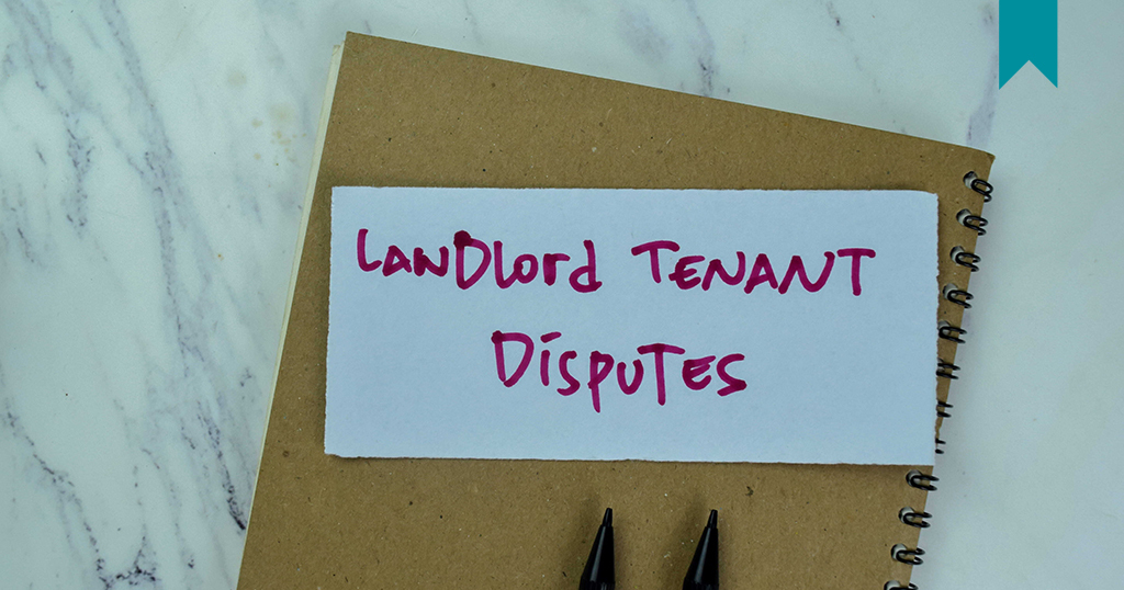 Landlord Tenant Disputes written on paper over notebook to represent documentation of issues.